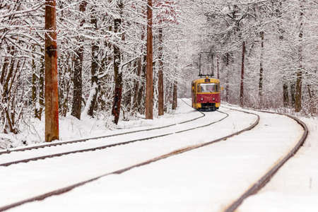 An old tram moving through a winter forest close upの写真素材