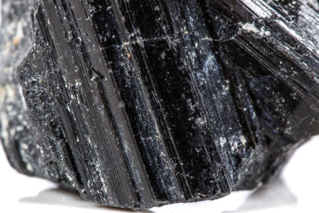 macro mineral stone sherle, schorl, black tourmaline on white background close-up