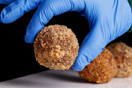 Beautiful candy truffle on a white plate on a black background close up