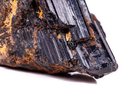 macro mineral stone sherle, schorl, black tourmaline on white background close-up