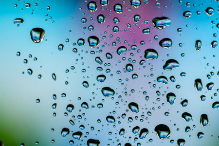 Beautiful multi-colored water droplets on a glass close-up