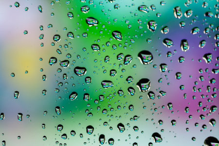 Beautiful multi-colored water droplets on a glass close-up