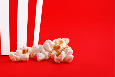 Glass with popcorn on a red backgroundの写真素材