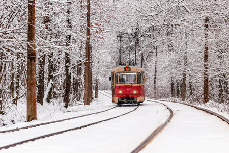 An old tram moving through a winter forest close upの写真素材