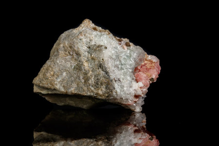 Macro of the mineral stone Rhodochrosite with fluorite on a black background close up