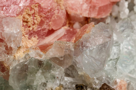 Macro of the mineral stone Rhodochrosite with fluorite on a black background close up