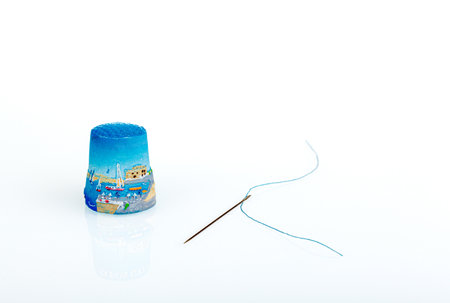 thimble and needle and thread on a white background close-up