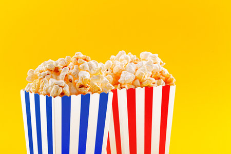 Glass with popcorn on a yellow background close-upの写真素材