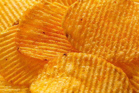 macro of beautiful corrugated yellow chips under the sun's rays close-upの写真素材