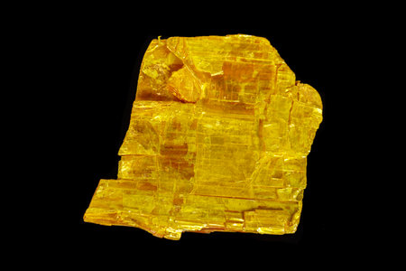 Macro stone Orpiment mineral on black background close up
