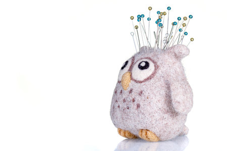pincushion in the form of an owl on a white background close-upの写真素材