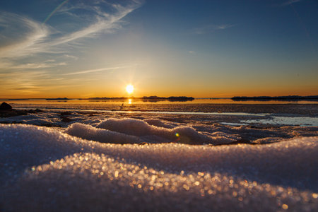 Beautiful winter sunset by the sea with iceberg close upの写真素材