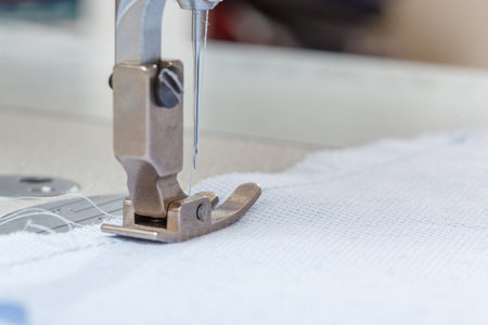 Sewing machine needle with thread and fabric close-up