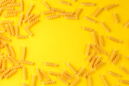 Different types and shapes of dry Italian pasta on a yellow background close-up
