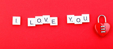 inscription love and red hearts on a red background close-upの写真素材