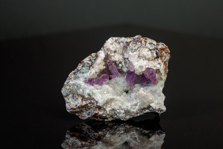 macro mineral amethyst stone in rock on a black background close-up