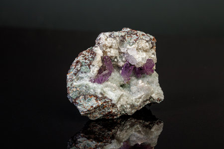 macro mineral amethyst stone in rock on a black background close-up