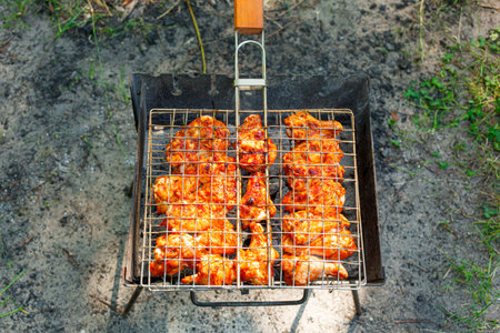 Cooking chicken wings and legs on the grill. Roasted meat on the grill close-upの写真素材