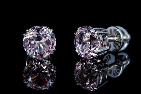 beautiful gold earrings with morganite gemstones on a black background close-upの写真素材