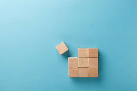 wooden cubes in a square of nine pieces in a row on a blue background close-upの写真素材