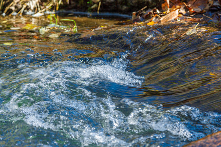 flow of water and spray from a stone close upの写真素材