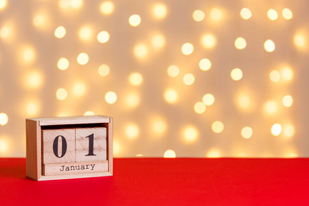 christmas, wooden calendar january 7 on red background and lights background close upの写真素材