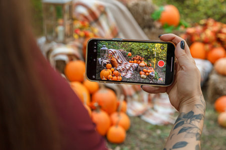 Beautiful autumn location with pumpkins in the phone, Halloween, close-upの写真素材