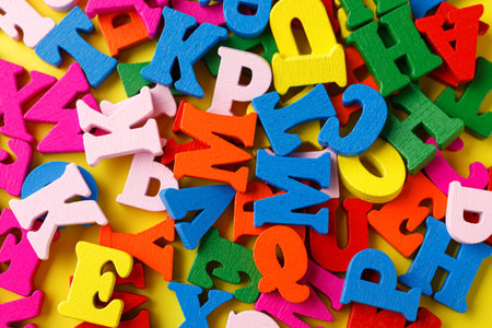 colored letters of the alphabet on a yellow background close-upの写真素材