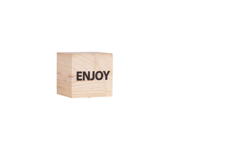 wooden cubes with the inscription Enjoy on a white isolated background close-upの写真素材