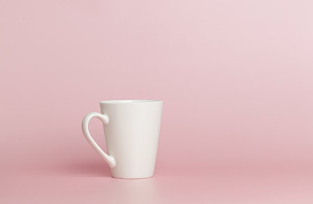 white cup for tea or coffee on a pink background close-upの写真素材