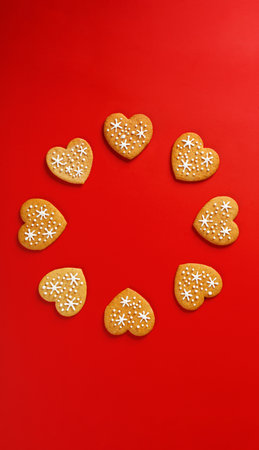 beautiful hand-baked cookies in the shape of a heart on a red background close-upの写真素材