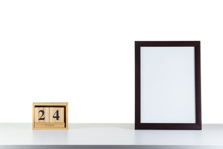 Wooden calendar with frame for photo on white table and background close-upの写真素材