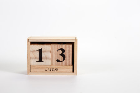 Wooden calendar June 13 on a white background close up