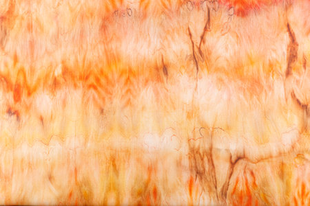 abstract pattern on silk fabric texture in yellow and brown tones close-upの写真素材