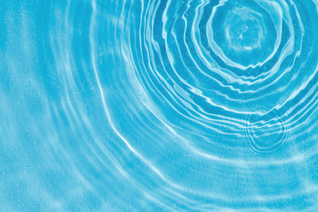 drops on water with circles on a blue background close upの写真素材