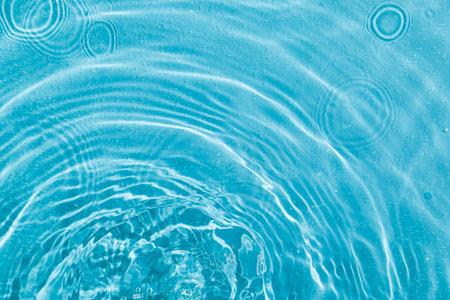 drops on water with circles on a blue background close up