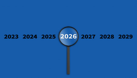 Lens, magnifying glass focusing on the year 2026 on a Blue background. Financial or stock market strategies and past and future events. Close-upの写真素材