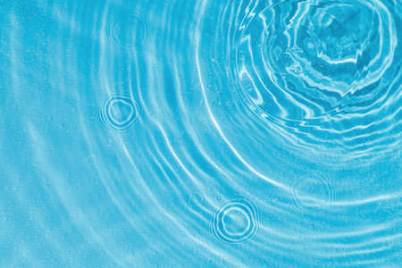 drops on water with circles on a blue background close upの写真素材