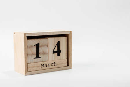 Wooden calendar March 14 on a white background close up