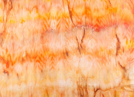 abstract pattern on silk fabric texture in yellow and brown tones close-upの写真素材