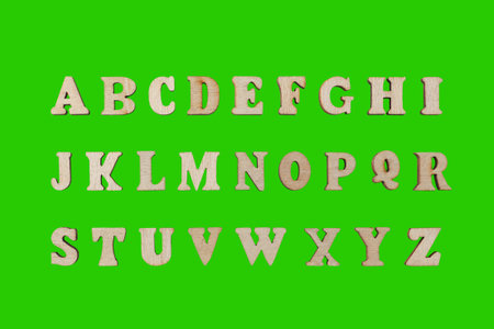 wooden letters of the English alphabet on a green background close-upの写真素材