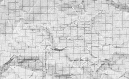 A crumpled checkered paper with dotted lines on a white background suits creative projects. Its textured surface adds a unique flair for artistic or recycling designs.の写真素材