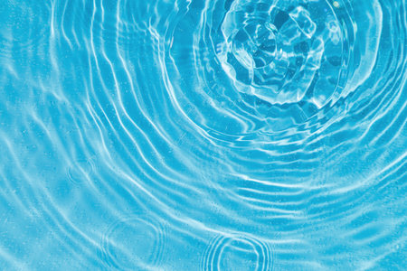 drops on water with circles on a blue background close up