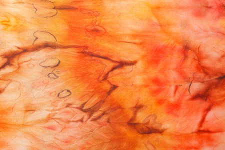abstract pattern on silk fabric texture in yellow and brown tones close-upの写真素材