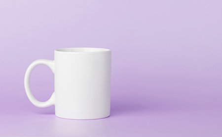 white cup for tea or coffee on a violet, purple background close-upの写真素材