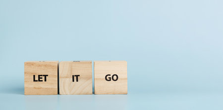 Wooden cubes with inscriptions Let It Go on a blue background close-upの写真素材
