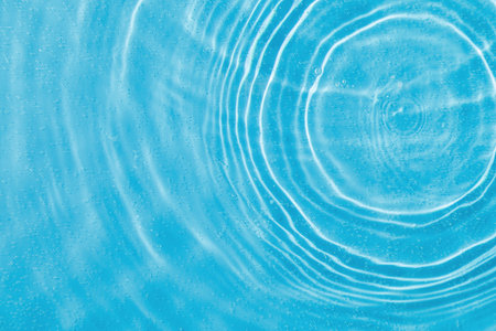 drops on water with circles on a blue background close upの写真素材