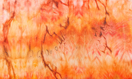 abstract pattern on silk fabric texture in yellow and brown tones close-upの写真素材