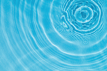 drops on water with circles on a blue background close upの写真素材