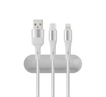 A rubber cable management clip with a non-slip base organizes multiple cables in a workspace. Its durable design maintains a clutter-free environment.の写真素材